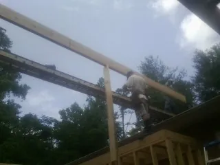 Carpenter setting a ridge beam over a new addition frame — Ice Dam Removal by Roofing Brothers in Bainbridge Island