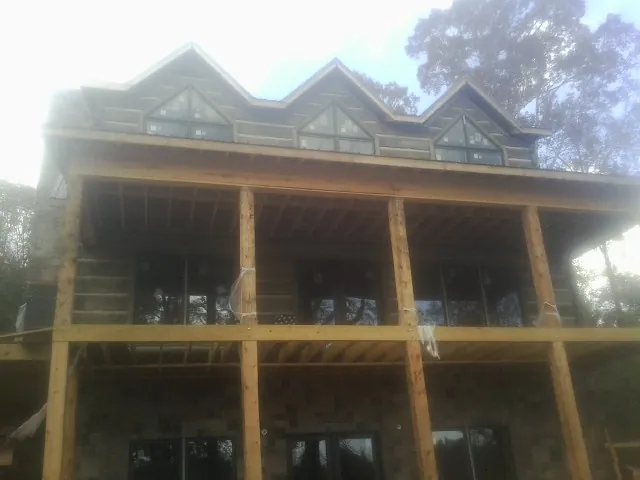 Dormers and porch framing on a large log home under construction — Roof Coating work by our crew in Bainbridge Island