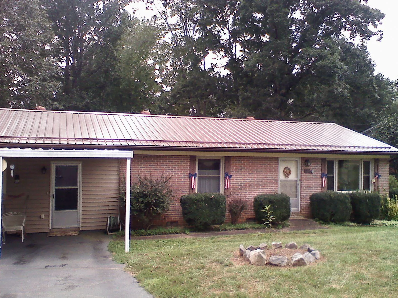 Bronze metal roof and carport on a brick ranch home — Roof Repair work by our crew in Bainbridge Island